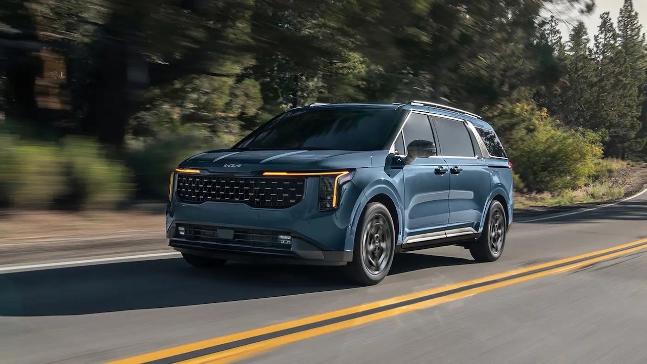 Vue 3/4 avant de la minifourgonnette Kia Carnival en pleine conduite.