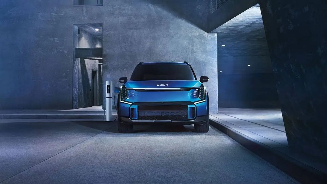 Vue latérale du Kia EV9 2025 sur la route, illustrant son design robuste et ses dimensions familiales.